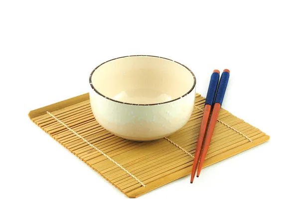 茶色の縁と白の小さなパターンを持つ空の円ベージュのセラミックボウル 白い背景に孤立竹マット上の箸 家庭やレストラン 食品のデザインのために使用されます キッチンアクセサリー — ストック写真