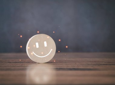 Kahverengi masanın üzerinde gülen ikon olan tahta bloğu çember yapın. Tatmin Oranı Konsepti