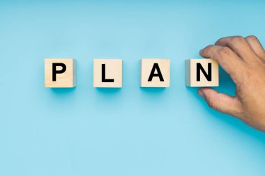 Ahşap blokta mavi arka planda el ele tutuşma planı. 