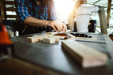 Marangoz bir ahşap kirişi kesiyor.