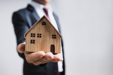 emlak ve yeni konut konsepti satın almak, banka temsilcisi ahşap ev göstermek kredi sunmak için müşteriye yeni ev 