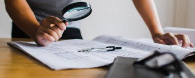Teftiş binası konsepti, müfettiş veya mühendis bina inşaatını şablon üzerinde büyüteç kullanarak kontrol ediyor