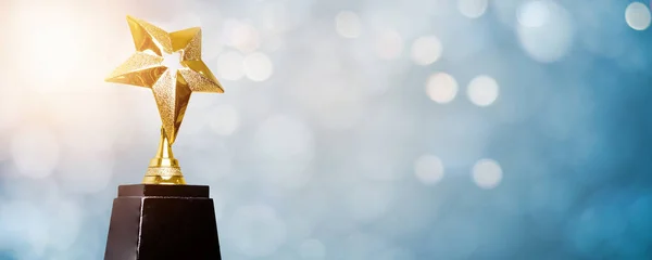 golden trophy award bokeh soft  blue background. copy space for text. Winner or 1st place gold trophy award concept