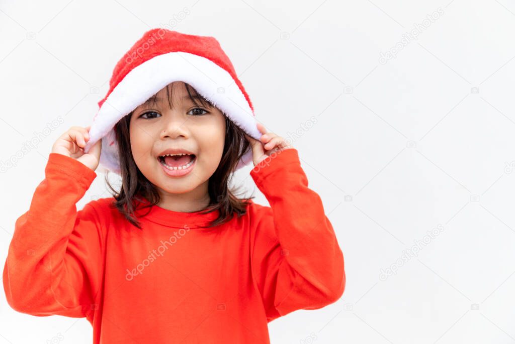 Asian little girl in red Santa hat on white background.