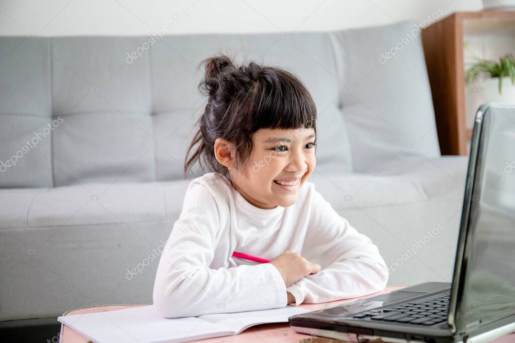 Asian girl student online learning class study online video call zoom teacher, Happy girl learn english language online with laptop at home.New normal.Covid-19 coronavirus.Social distancing.stay home