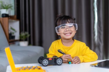 Evde robot araba yapan yaratıcı bir çocuk.