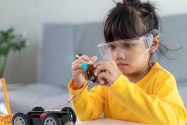 Evde robot araba yapan yaratıcı bir çocuk.