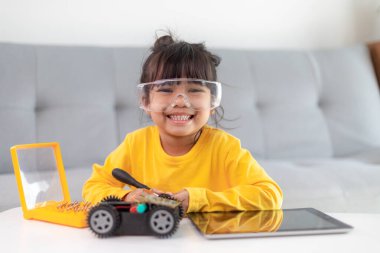 Evde robot araba yapan yaratıcı bir çocuk.
