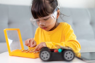 Evde robot araba yapan yaratıcı bir çocuk.