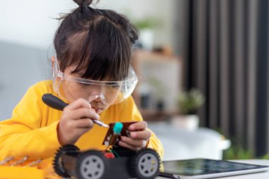 Asyalı öğrenciler evlerinde robot arabaları ve elektronik tahta kablolarını STEM, STEAM, matematik mühendisliği, bilim teknolojisi bilgisayar kodlarını çocuk konsepti için robotikte kodlayarak öğreniyorlar..