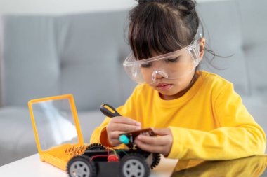 Evde robot araba yapan yaratıcı bir çocuk.