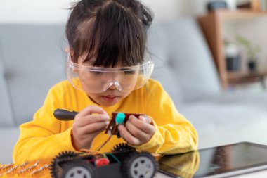 Evde robot araba yapan yaratıcı bir çocuk.