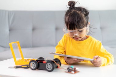Asyalı öğrenciler evlerinde robot arabaları ve elektronik tahta kablolarını STEM, STEAM, matematik mühendisliği, bilim teknolojisi bilgisayar kodlarını çocuk konsepti için robotikte kodlayarak öğreniyorlar..