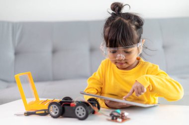 Asyalı öğrenciler evlerinde robot arabaları ve elektronik tahta kablolarını STEM, STEAM, matematik mühendisliği, bilim teknolojisi bilgisayar kodlarını çocuk konsepti için robotikte kodlayarak öğreniyorlar..
