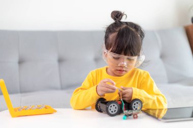 Evde robot araba yapan yaratıcı bir çocuk.