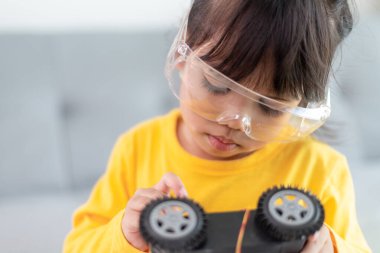 Asyalı öğrenciler evlerinde robot arabaları ve elektronik tahta kablolarını STEM, STEAM, matematik mühendisliği, bilim teknolojisi bilgisayar kodlarını çocuk konsepti için robotikte kodlayarak öğreniyorlar..