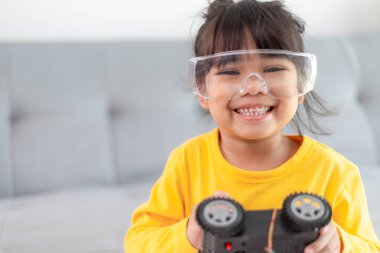 Evde robot araba yapan yaratıcı bir çocuk.