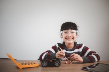 Evde robot araba yapan yaratıcı bir çocuk.