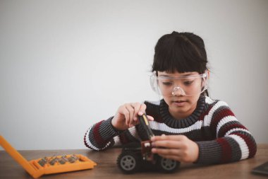 Evde robot araba yapan yaratıcı bir çocuk.