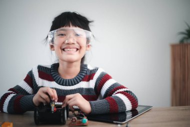 Asyalı öğrenciler evlerinde robot arabaları ve elektronik tahta kablolarını STEM, STEAM, matematik mühendisliği, bilim teknolojisi bilgisayar kodlarını çocuk konsepti için robotikte kodlayarak öğreniyorlar..
