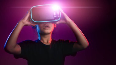 Sanal gerçeklik gözlüklü mutlu kız. Gelişmiş gerçeklik, bilim, gelecekteki teknoloji konsepti. Video kayıt cihazı. Sanal projeksiyonlu fütüristik 3D gözlükler. Neon ışığı.