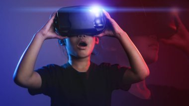 Sanal gerçeklik gözlüklü mutlu kız. Gelişmiş gerçeklik, bilim, gelecekteki teknoloji konsepti. Video kayıt cihazı. Sanal projeksiyonlu fütüristik 3D gözlükler. Neon ışığı.