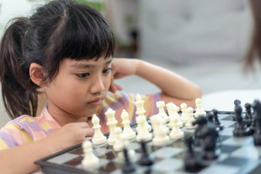 Evde satranç oynayan küçük kardeş kız..