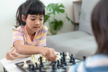 Evde satranç oynayan küçük kardeş kız..