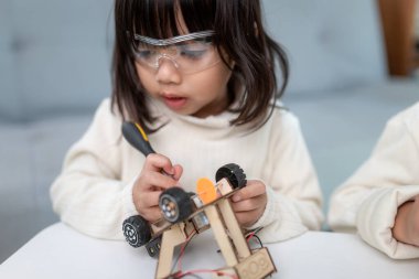 Evde robot araba yapan yaratıcı bir çocuk.