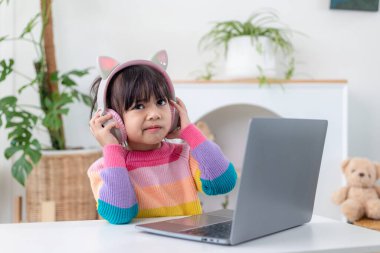 Ev karantinası sırasında bilgisayar kullanarak evde eğitim alan Asyalı bir kız. evde eğitim, çevrimiçi öğrenim, ev karantinası, çevrimiçi öğrenim, korona virüsü veya eğitim teknolojisi kavramı