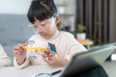 Evde robot araba yapan yaratıcı bir çocuk.
