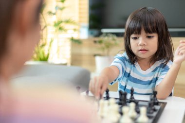 Evde satranç oynayan küçük kardeş kız..