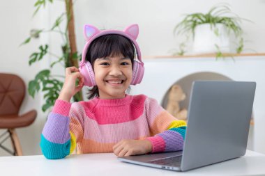 Ev karantinası sırasında bilgisayar kullanarak evde eğitim alan Asyalı bir kız. evde eğitim, çevrimiçi öğrenim, ev karantinası, çevrimiçi öğrenim, korona virüsü veya eğitim teknolojisi kavramı