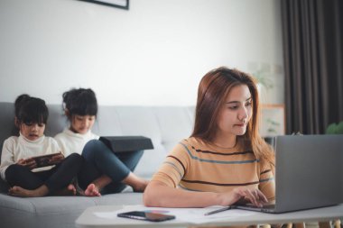 Merkez ofis. Evden çalışmaya karşı. İki çocuklu anne evde dizüstü bilgisayarda çalışıyor. Karantinaya alındı. Corona Virüsü.