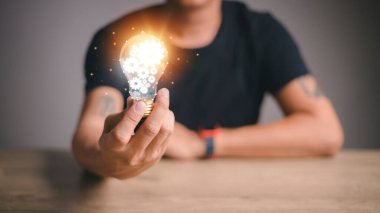 The hand of a man with a light bulb.The idea of inspiration from online technology.innovation idea concept.   