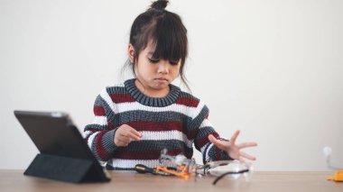 Evde robot araba yapan yaratıcı bir çocuk.