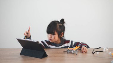 Evde robot araba yapan yaratıcı bir çocuk.