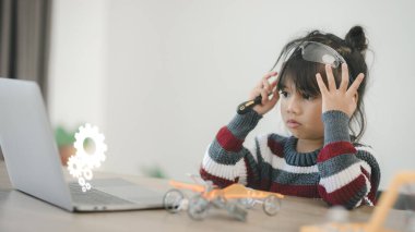 Evde robot araba yapan yaratıcı bir çocuk.