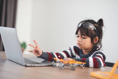 Evde robot araba yapan yaratıcı bir çocuk.