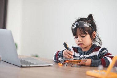 Evde robot araba yapan yaratıcı bir çocuk.