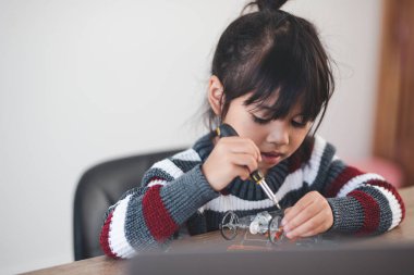 Evde robot araba yapan yaratıcı bir çocuk.