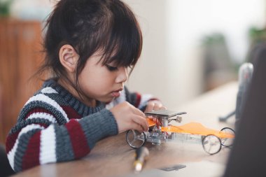 Evde robot araba yapan yaratıcı bir çocuk.