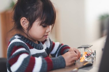 Evde robot araba yapan yaratıcı bir çocuk.