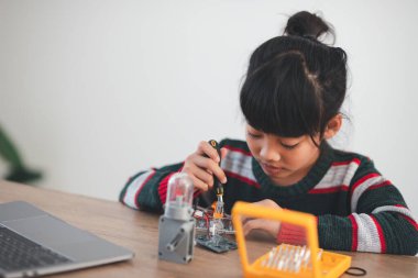 Evde robot araba yapan yaratıcı bir çocuk.