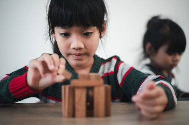 Cheerful Asian girl playing with wooden building blocks. Having fun and learning creativity. smart kid concept.