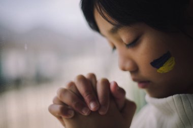 Ukrayna bayrağı taşıyan bir çocuk ağlıyor. Üzüntü, umut özlemi. Savaştan kalan çocukların gözyaşları. Sivillerin tahliyesi. Ukrayna 'ya Özgürlük