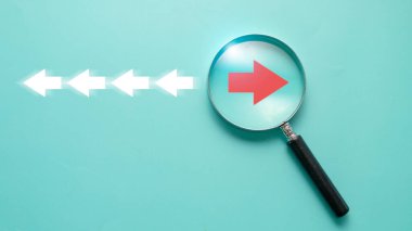 Büyüteç camının içindeki kırmızı ok ve odak noktası bozulması ve teknoloji dönüşümü kavramı için beyaz oktan farklı yön.