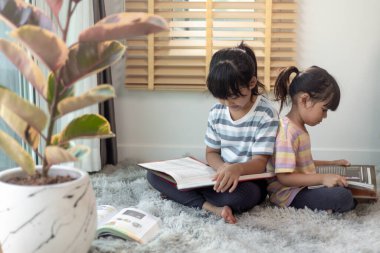 Kitap okuyan konsantre kardeşler.
