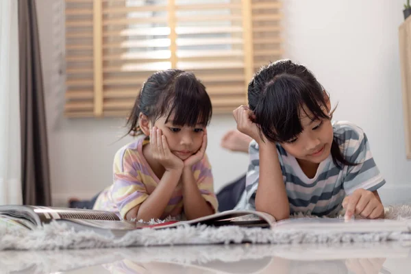 Concentrated Siblings Reading Book — Zdjęcie stockowe