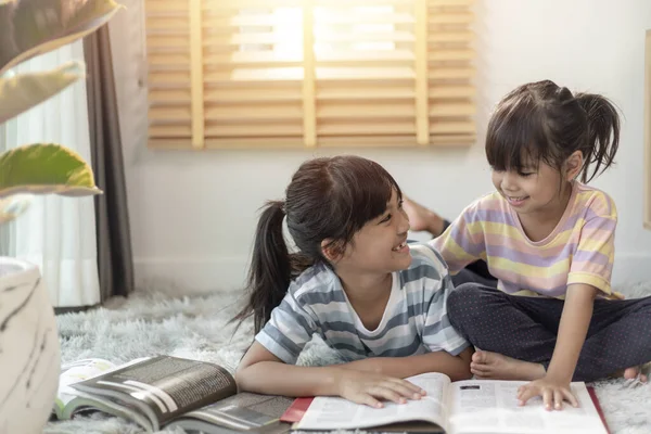 Kitap okuyan konsantre kardeşler.